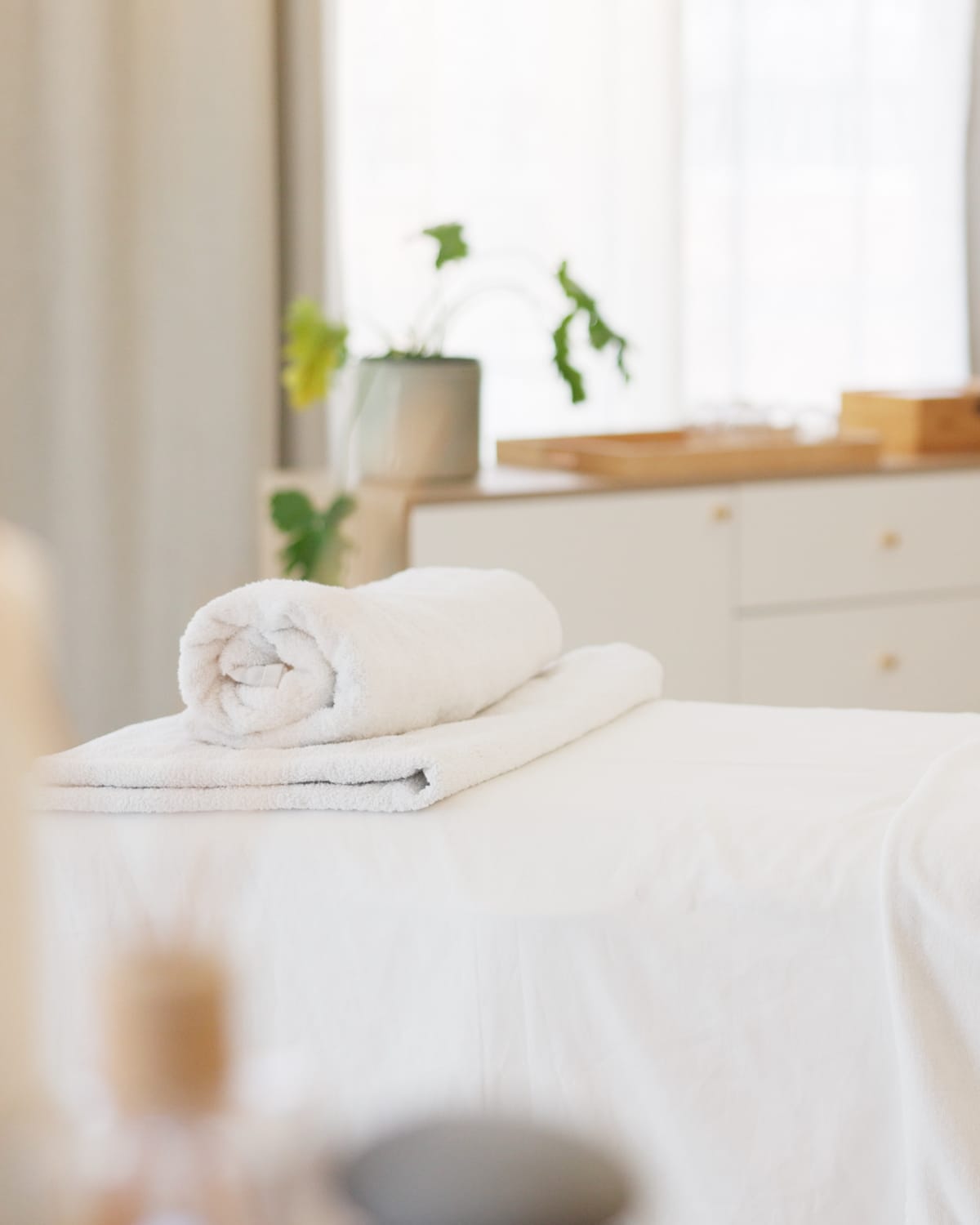 A massage table dressed with fresh towels in a bright, quiet room